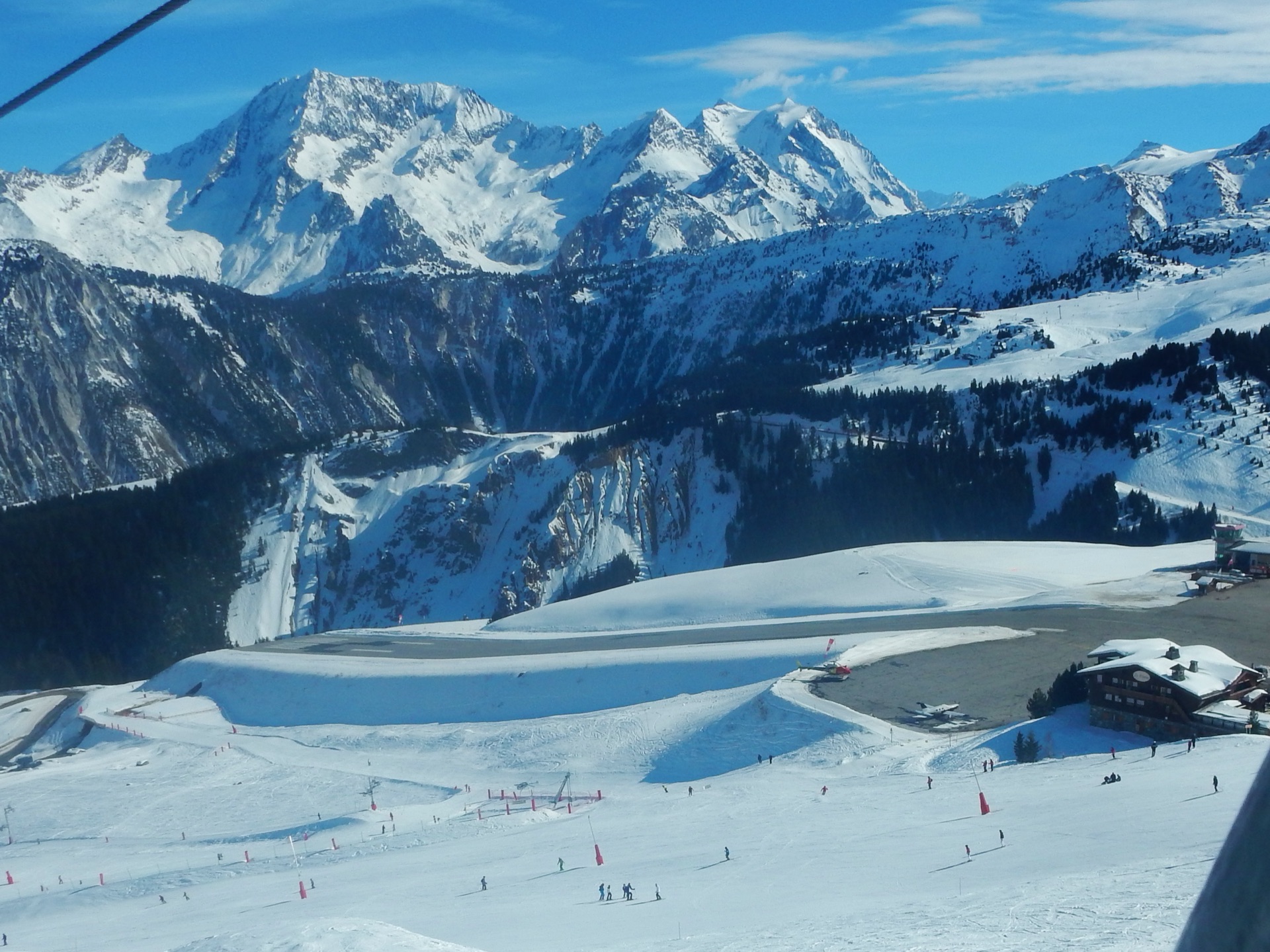 Courchevel altiport and ski slopes below snow-covered peaks in the French Alps